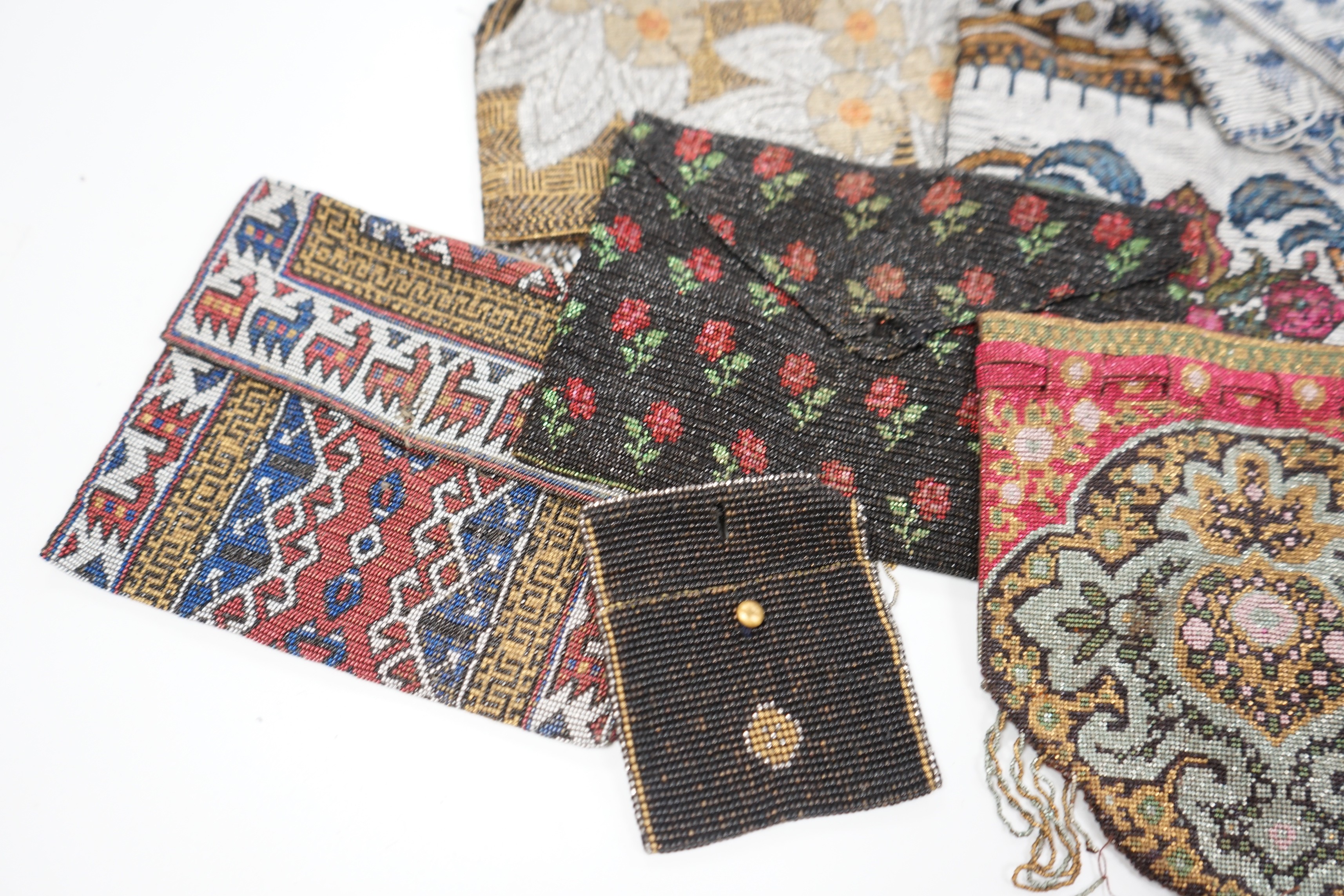Seven late 19th century multicoloured and designed cut steel evening bags and a small coin purse (8)